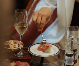 a hand holding a fork grabbing food from a plate