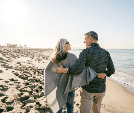 an older couple walking on the beach